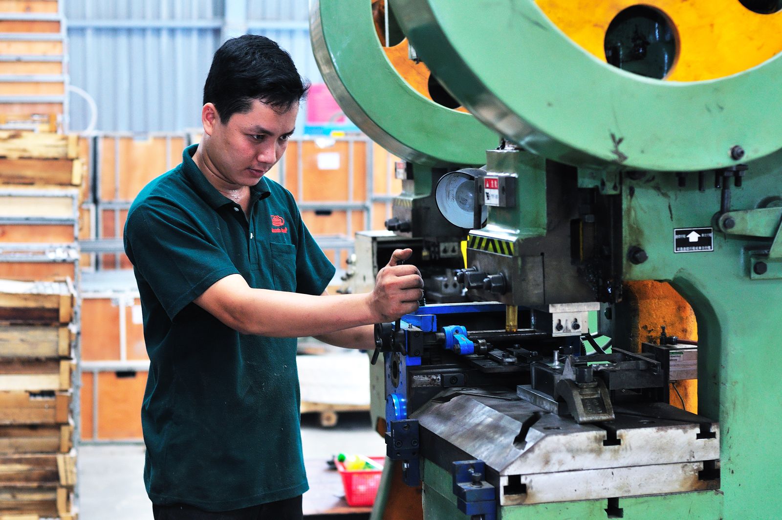 Operador ajustando una máquina industrial dentro de una fábrica
