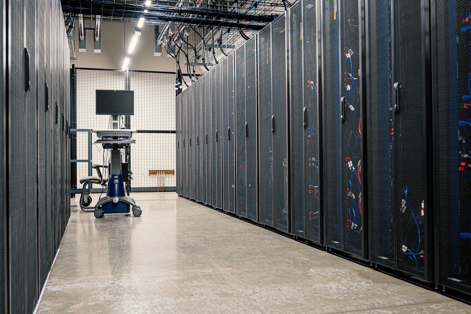 Pasillo de un centro de datos con gabinetes de servidores a ambos lados