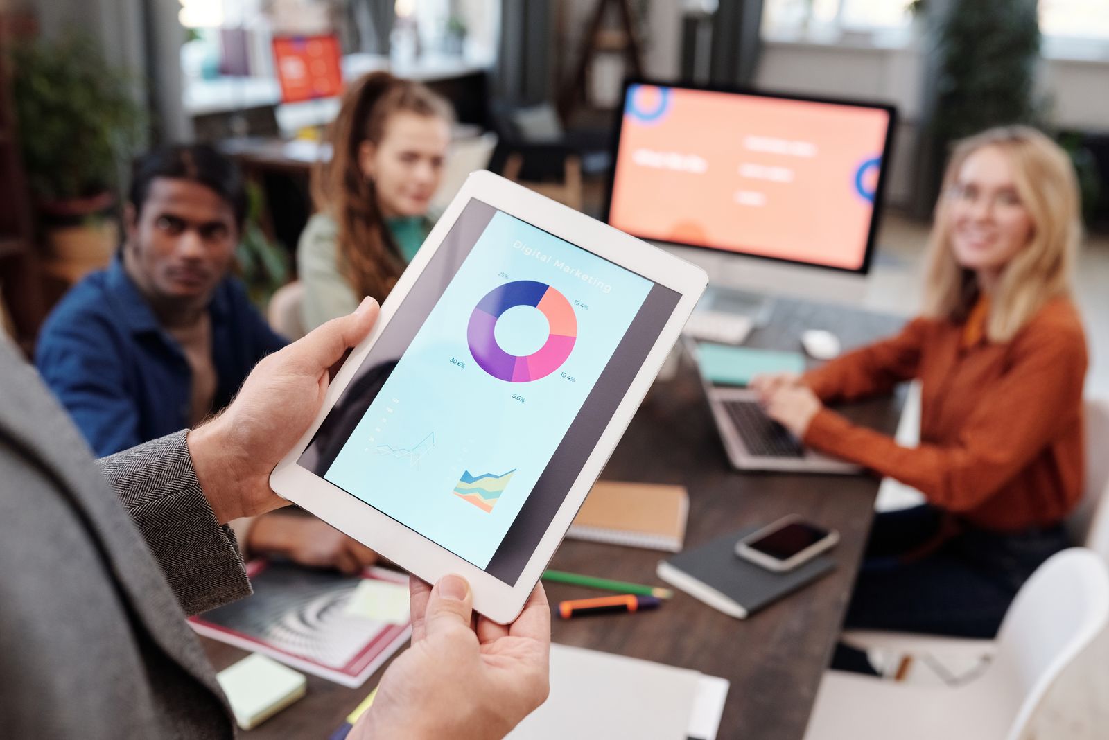 Equipo de trabajo analizando un gráfico en una tableta durante una reunión